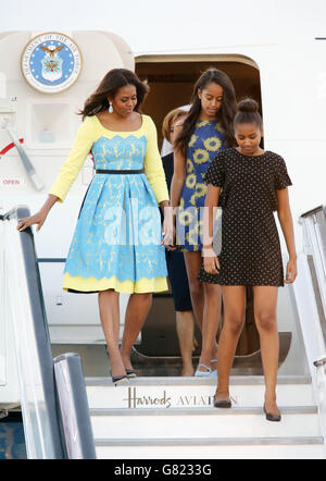 LA prima signora DEGLI STATI UNITI Michelle Obama accompagnata dalle sue figlie, Malia e Sasha (davanti), a pochi passi da un aereo, come lei arriva a Stansted Airport, Essex, per una visita nel Regno Unito, per promuovere le sue campagne per l'educazione delle ragazze e un migliore sostegno per le famiglie militari. Foto Stock