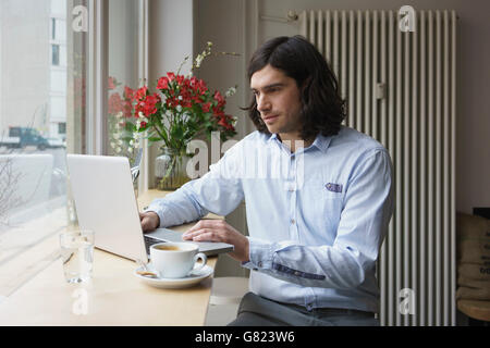 Uomo con notebook mentre un caffè al caffè Foto Stock