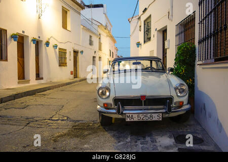 Vecchie MG B classic car, parcheggiata in strada in bianco al villaggio spagnolo. Mijas, serata. Spagna. Foto Stock