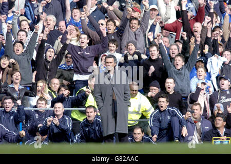 Calcio - fa Barclays Premiership - Chelsea / Birmingham City - Stamford Bridge. Il manager del Chelsea Jose Mourinho guarda la partita mentre i tifosi celebrano il loro obiettivo contro Birmingham City Foto Stock