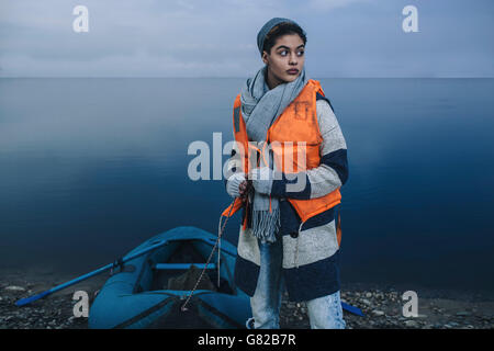 Ragazza adolescente con zattera gonfiabile in piedi sul lago Foto Stock