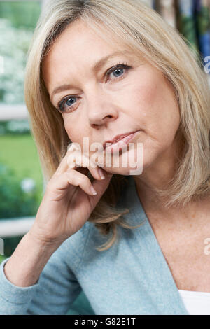 Testa e spalle Ritratto di premurosa donna matura a casa Foto Stock