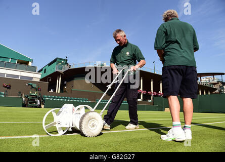 Le linee sono dipinte sul campo piacevole prima del giorno tre dei Campionati di Wimbledon all'All England Lawn Tennis and Croquet Club, Wimbledon. Foto Stock