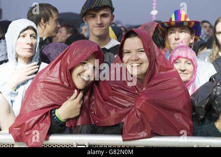 I festaioli si rifugiano dalla pioggia, mentre le Black Keys si esibiscono il primo giorno dell'Isle of Wight Festival 2015, Seaclose Park, Isle of Wight Foto Stock