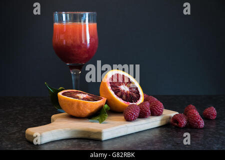 Arancio sanguigno, frutti di bosco e un bicchiere di spremuta fresca Foto Stock