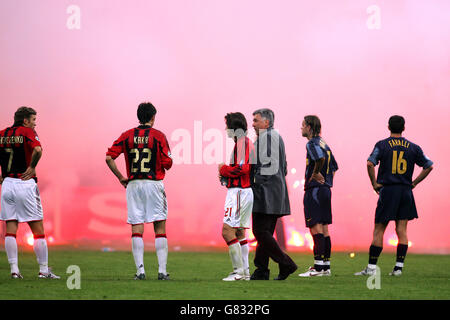 I giocatori di Inter Milan e AC Milan si levano in piedi intorno dopo i flares Sono stati gettati dai fan di Inter Milan forzando il gioco essere abbandonati Foto Stock