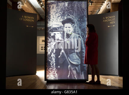 La curatrice della mostra Anna Sparham ispeziona un ritratto di Christina Brok, alto 2 metri, stampato su vetro, che è stato installato presso il Museum of London Docklands prima dell'apertura della loro ultima mostra Soldiers and Suffragettes: La Fotografia di Christina Broon, una mostra gratuita aperta al pubblico da venerdì 19 giugno. Foto Stock