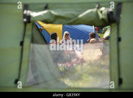 I festivalgoers si rilassano dopo essere arrivati al Festival di Glastonbury presso la Worthy Farm nel Somerset. Foto Stock