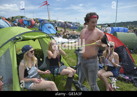 Chloe, 22, (cognome non dato) ha bevuto il sidro di frutta attraverso un imbuto e un tubo, conosciuto anche come 'chugging' al festival di Glastonbury, a Worthy Farm in Somerset. Foto Stock