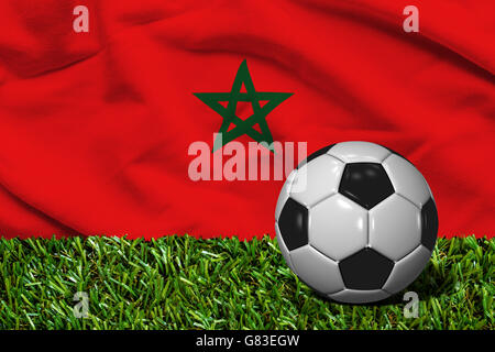 3D reso pallone da calcio in erba campo con la bandiera del Marocco come sfondo Foto Stock