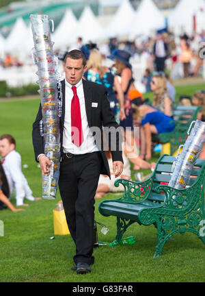 Un amministratore raccoglie le caraffe vuote dopo l'ultima gara del Ladies Day, il terzo giorno del Royal Ascot Meeting 2015 all'ippodromo di Ascot, Berkshire. Foto Stock