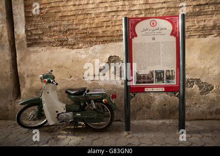 Un sito culturale marcatore sorge lungo una strada stretta nella Medina di Marrakech, Marocco. Foto Stock