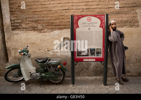 Un sito culturale marcatore sorge lungo una strada stretta nella Medina di Marrakech, Marocco. Foto Stock