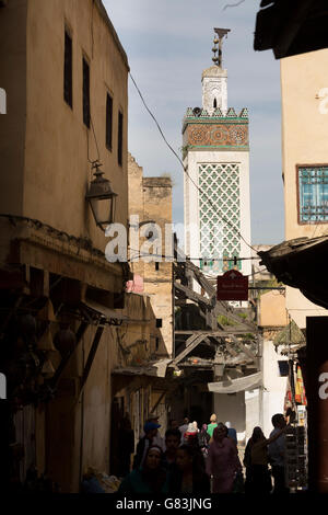 Un antico minareto torreggia su stradine della vecchia medina di Fez, in Marocco. Foto Stock