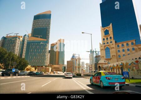 Si entra nel centro di Doha, in Qatar, il Majlis Al Taawon Street. Barzan torre sulla destra Qatar Petroleum District complesso sulla sinistra Foto Stock