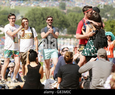 Ben Keating (seconda a destra) sorprende il suo partner Beth Ryan proponendo a lei al Glastonbury Festival, presso la Worthy Farm di Somerset. Foto Stock