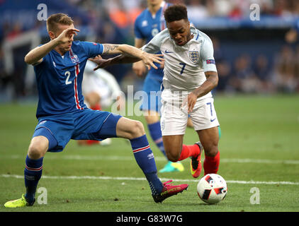 Il Raheem Sterling inglese e il Birkir Mar Saevarsson islandese (a sinistra) combattono per la palla durante il round del 16 allo Stade de Nice, Nizza, Francia. PREMERE ASSOCIAZIONE foto. Data foto: Lunedì 27 giugno 2016. Vedi la storia della Pennsylvania Soccer Inghilterra. Il credito fotografico deve essere: Nick Potts/PA Wire. RESTRIZIONI: L'uso è soggetto a restrizioni. Solo per uso editoriale. Le vendite di libri e riviste sono consentite fornendo non esclusivamente dedicato a una sola squadra/giocatore/partita. Nessun uso commerciale. Chiamare il numero +44 (0)1158 447447 per ulteriori informazioni. Foto Stock