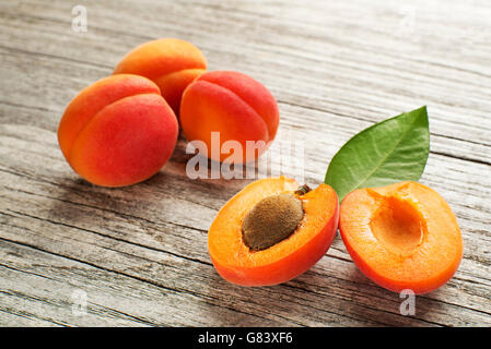 Fresche albicocche tagliate la frutta in background in legno Foto Stock