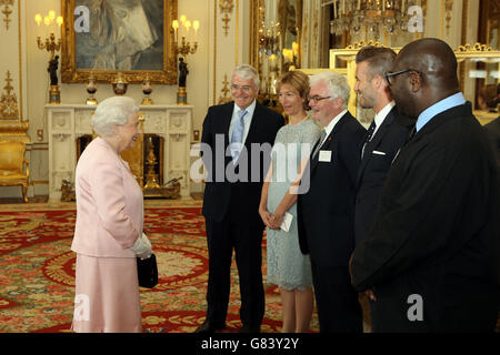 La regina Elisabetta II parla con l'ospite, tra cui Sir John Major, David Beckham e Steve McQueen, in una reception a Buckingham Palace per celebrare il programma dei giovani leader della regina e per presentare i premi ai primi vincitori di successo del progetto Commonwealth. Foto Stock