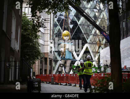 Una scultura di 7 metri di altezza di Damien Hirst, intitolata Charity (2002-2003), è installata accanto alla Chiesa di Sant'Elena di fronte all'edificio Gherkin nel Square Mile di Londra, come parte dell'edizione 2015 del programma di installazione della City of London's Sculpture in the City. Foto Stock