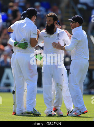 Il bowler dell'Inghilterra Moeen Ali celebra il lancio del wicket del batsman australiano Steve Smith per il 33 catturato da Alastair Cook (a sinistra) , durante il primo Investec Ashes Test allo stadio SWALEC di Cardiff. Foto Stock