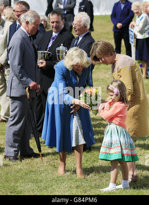 La Duchessa di Cornovaglia viene consegnata da una giovane ragazza un bouquet di fiori durante la sua visita con il Principe di Galles a Sandringham spettacolo di fiori tenuto nella Royal Estate a Norfolk. Foto Stock