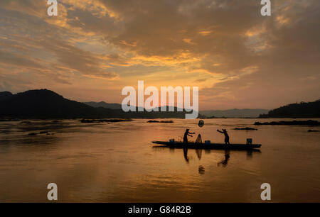 Silhouette di due pescatori di gettare reti nel fiume Mekong, Thailandia Foto Stock