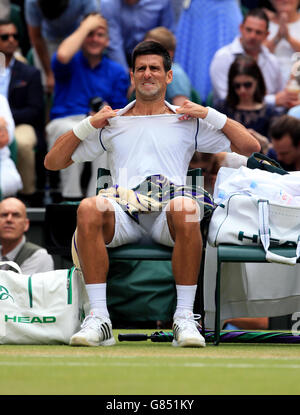 Novak Djokovic mostra la sua frustrazione quando perde il secondo set a Roger Federer nella finale di Mens Singles durante il tredici giorno dei Campionati di Wimbledon presso l'All England Lawn Tennis and Croquet Club di Wimbledon. Foto Stock