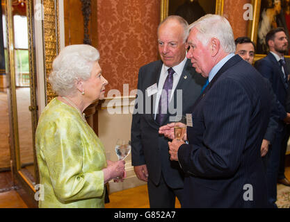 La Regina Elisabetta II incontra David Walls (al centro) e Thomas Irwin di Accuracy International ad un ricevimento per i vincitori dei Queen's Awards for Enterprise 2015, a Buckingham Palace, Londra. Foto Stock