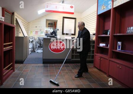 Manzoor Alam, 73 anni, il nuovo postmaster del più antico ufficio postale del mondo, spazza il pavimento dell'ufficio postale di Sanquhar a Dumfries e Galloway. Foto Stock