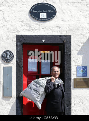 Manzoor Alam, 73 anni, il nuovo postmaster per il più antico ufficio postale del mondo, passa accanto all'ufficio postale di Sanquhar a Dumfries e Galloway. Foto Stock