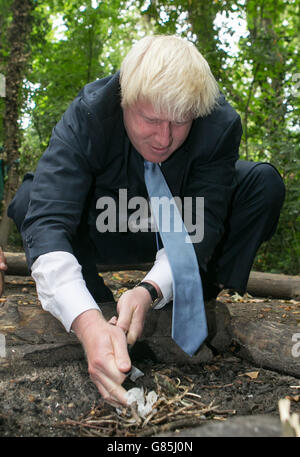 Il sindaco di Londra Boris Johnson prepara un incendio durante una visita a Shooters Hill Woodland presso il Wide Horizons Environment Center, Londra. Foto Stock