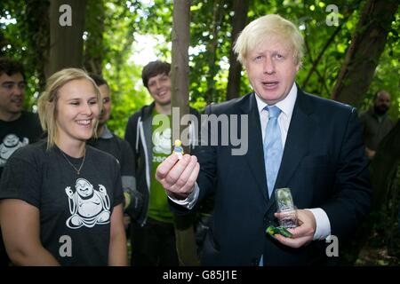 Il Sindaco di Londra Boris Johnson guarda un uomo giocattolo Lego che gli è stato dato un volontario locale durante una visita a Shooters Hill Woodland presso il Wide Horizons Environment Center di Londra. Foto Stock