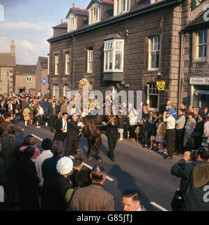 L'autista di una petroliera di cemento di quarant'anni, Gerald Melody in veste di re Carlo, è coperto di fiori e sta cavalcando Charlotte è processione per celebrare Garland Day in Oak Apple Day a Castleton, Derbyshire. La cerimonia risale effettivamente ai tempi pre-Stuart ai riti pagani. 29/05/1967 Foto Stock