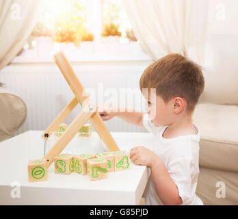 Little Boy giocando con abacus toy in ambienti interni Foto Stock