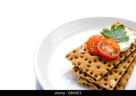 Una sana low carb colazione snack sul piatto bianco, fette biscottate e fresche tomatoe sulla crema di formaggio con prezzemolo e pepe Foto Stock