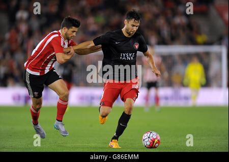 Shane Long di Southampton e Tim Sparv (a destra) del FC Midtjylland combattono per la palla durante la UEFA Europa League, Qualifying Play-off, prima tappa al St Mary's Stadium di Southampton. Foto Stock