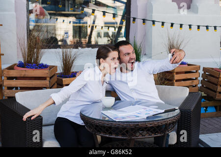 Happy business giovane tenendo selfie presso un ristorante esterno Foto Stock