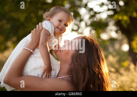 Sollevamento madre bambina in aria Foto Stock