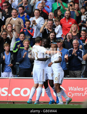 Il Bafetimbi Gomis (centro) di Swansea City celebra il primo gol della partita del suo fianco durante la partita della Barclays Premier League al Liberty Stadium, Swansea. Foto Stock