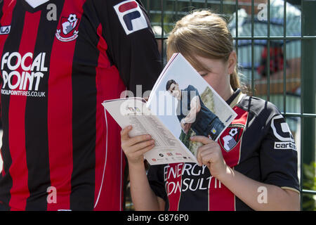 Un giovane fan di AFC Bournemouth legge il programma del giorno della partita Al di fuori del Vitality Stadium prima della partita Foto Stock