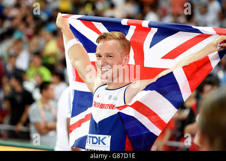 Greg Rutherford della Gran Bretagna festeggia con una bandiera Union Jack dopo aver vinto l'oro nel Long Jump durante il quarto giorno dei Campionati Mondiali IAAF allo Stadio Nazionale di Pechino, in Cina. Foto Stock