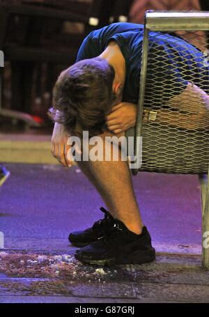 Un turista si riposa nelle prime ore del mattino a Punta Ballena, la principale striscia di club di Magaluf, Maiorca, Spagna. Foto Stock