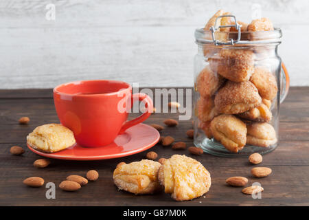 Cottage cheese biscotti ricoperti di miele con tè nero in rosso coppa. Profondità di campo. Foto Stock