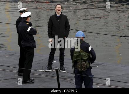 Il Cancelliere dello scacchiere George Osborne (seconda destra) ride mentre parla con gli ufficiali navali su un sottomarino alla base sottomarina della Royal Navy a Faslane, Scozia. Foto Stock