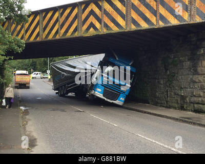 Un camion bloccato a Milngavie vicino a Glasgow dopo che il conducente ha tentato di guidare sotto un ponte basso. Foto Stock