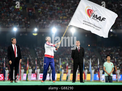 Il capitano della Gran Bretagna Martyn Rooney fa la bandiera dell'IAAF mentre il presidente della UK Athletic Lynn Davies (a sinistra) guarda durante il 9° giorno dei Campionati del mondo IAAF allo Stadio Nazionale di Pechino, in Cina. Foto Stock