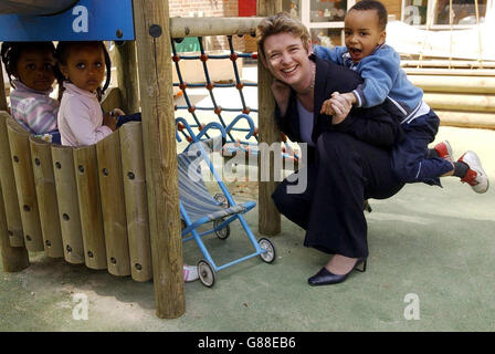 Marco Lopes (a destra), di 3 anni, si prende cura del Segretario di Stato per l'Educazione e le competenze Ruth Kelly durante una visita ad un centro giochi per bambini a Camden. Foto Stock