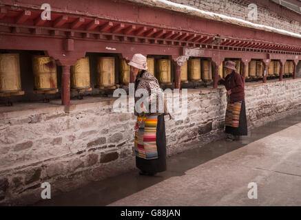 SHIGATSE, nel Tibet - Maggio 2016 - Due donne spin ruote della preghiera in un circuito di Kora intorno a Tashi Lhanpo monastero a Shigatse, nel Tibet. Foto Stock