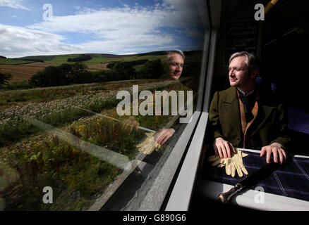 Fergus John McCann come Sir Walter Scott vede la campagna mentre viaggia su un treno ferroviario Borders da Tweedbank a Edimburgo, la più lunga ferrovia nazionale ad aprire nel Regno Unito per più di un secolo, prima dei loro servizi a partire da questo fine settimana. Foto Stock